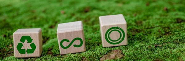 Symbol för avfallsminskning, föroreningar, återanvändning, effektiv resursanvändning. Miljöskyddsskylt genom återvinning på cirkulär träskiva på naturbakgrund.