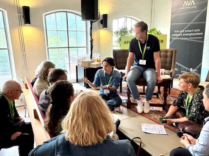 Människor sitter i en ring och diskuterar.